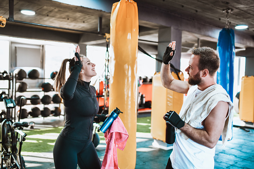 High Five By Smiling Couple In Modern Gym After Tough Training