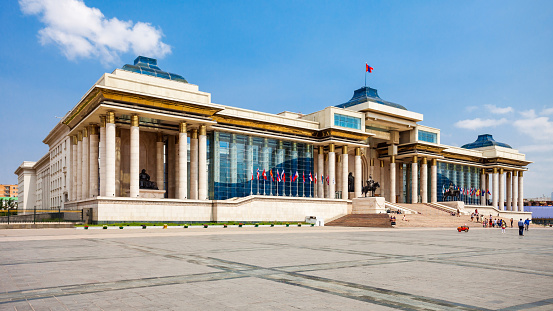 Ulaanbataar, Monogolia - August 19, 2015: Chinggis Square, still commonly referred to as Sükhbaatar Square, is the central square of Mongolia's capital Ulaanbaatar. It is also a primary gathering place for families, tourists and wedding parties, who take pictures in front of Chinggis Khan's statue. The main government building is in the background.