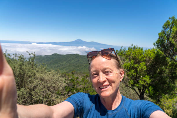 Women taking selfie in Valle Gran Rey - view of volcano El Teide in distance stock photo