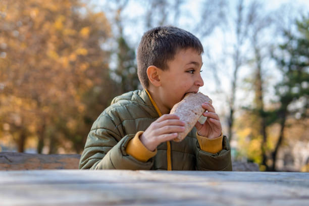istock Boy eating homemade bread in the park 1353089150