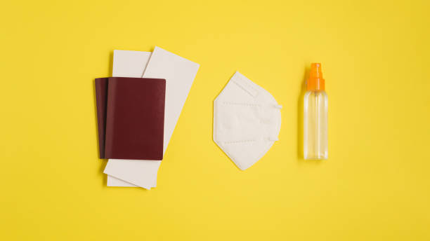 istock Passport, mask and disinfection on yellow background. Top view composition. 1353092043
