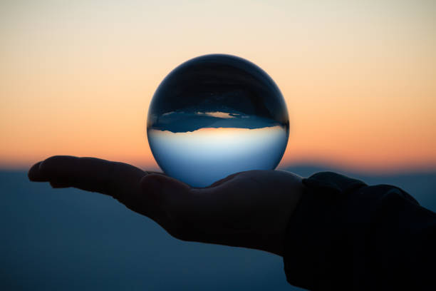 istock Hand holding a crystal ball at sunset 1353092275