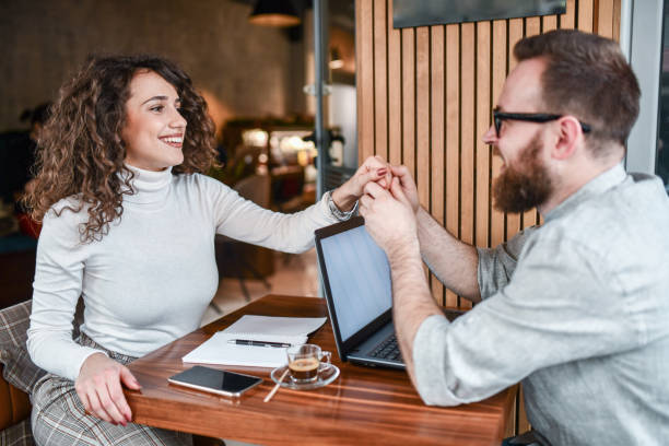 istock Smiling Couple Holding Hands And Enjoying Romance While Working Together At Home 1353093886