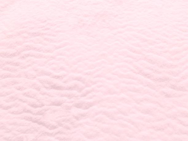 istock Pink white snow winter background. Snowy wavy texture. 1353096437