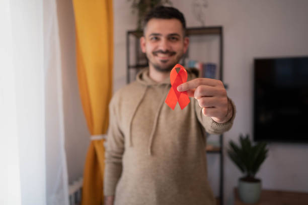 istock Caucasian man holding red hiv aids ribbon. 1353097911