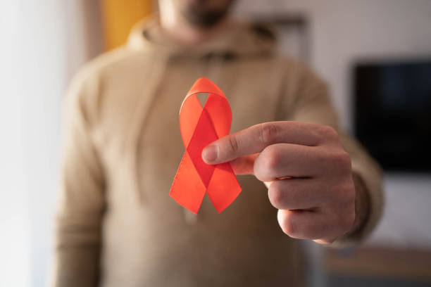 istock Caucasian man holding red hiv aids ribbon. 1353097914