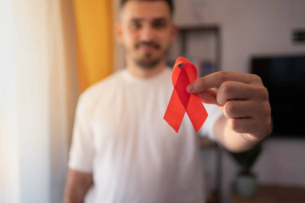 istock Caucasian man holding red hiv aids ribbon. 1353097928