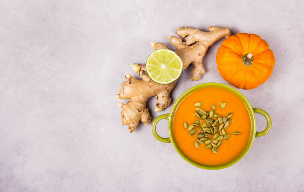 Spicy pumpkin cream soup with ginger and lime stock photo