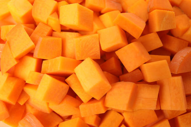 istock Cubes of fresh ripe carrots as background, top view 1353098190