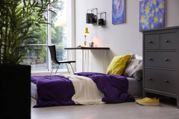 istock Modern teenager's room interior with comfortable bed, workplace and stylish design elements 1353098892