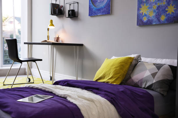 Modern teenager's room interior with comfortable bed, workplace and stylish design elements