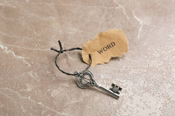 istock Vintage key with tag on grey table. Keyword concept 1353099136
