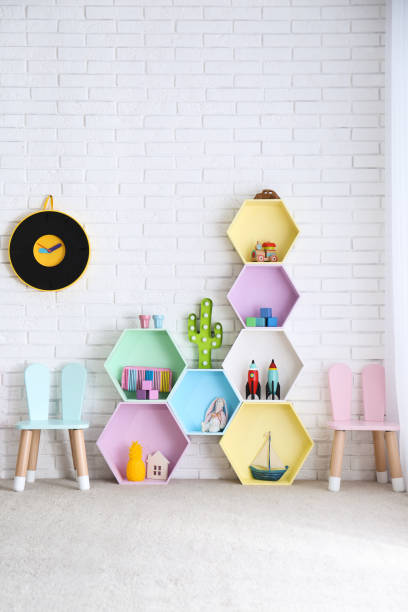 istock Child room interior with colorful shelves near brick wall 1353099233