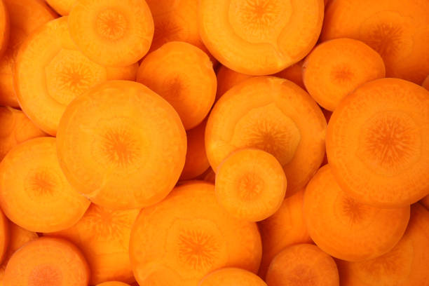istock Slices of fresh ripe carrots as background, top view 1353099575