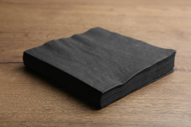 stack of black clean paper tissues on wooden table - black backgound imagens e fotografias de stock