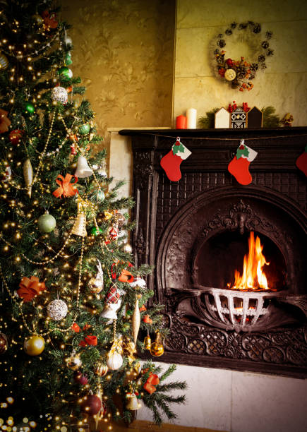 istock Decorated Christmas tree near a burning fireplace. Christmas atmosohere 1353101839