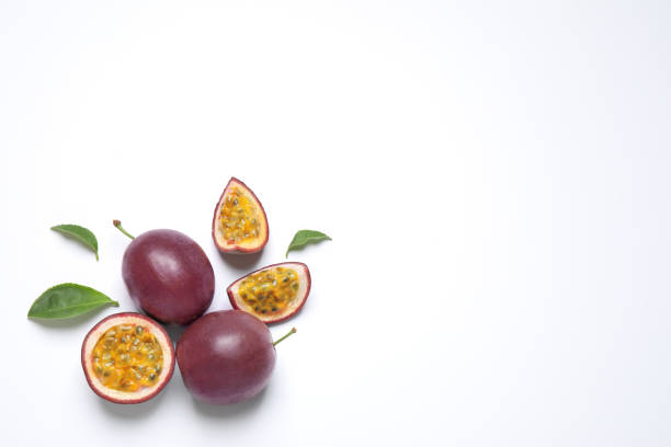 frutas de la pasión frescas maduras (maracuyas) con hojas sobre fondo blanco, puesta plana. espacio para texto - parchita fotografías e imágenes de stock