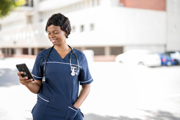 istock African nurse using smart phone outside hospital 1353103557