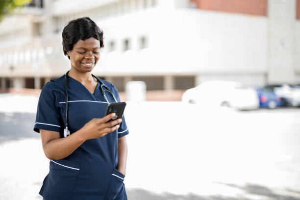 istock African nurse using smart phone outside hospital 1353103558
