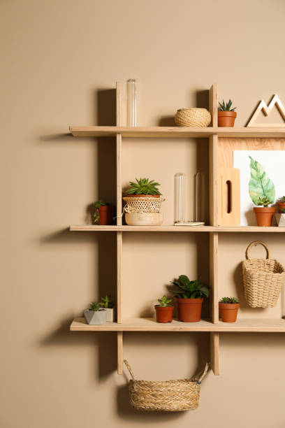 istock Wooden shelves with different decorative elements on beige wall 1353104460