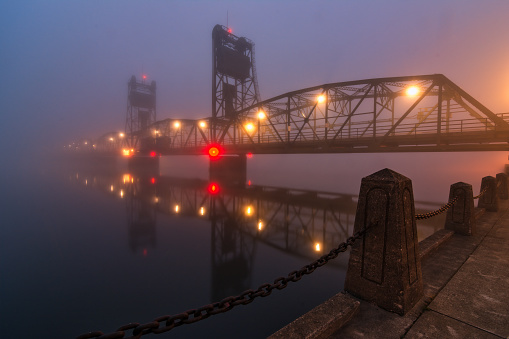 still water lift bridge reflection on a foggy morning