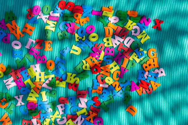 Colorful letters on blue background Colorful letters on blue background. English alphabet close up. Scattered wooden multicolored letters magnetic letter stock pictures, royalty-free photos & images