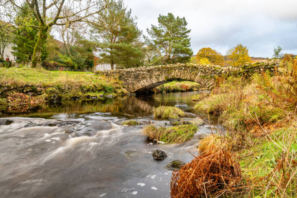 ponte pedonale in pietra su watendlath beck a watendlath tarn nel lake district in cumbria, inghilterra - watendlath foto e immagini stock