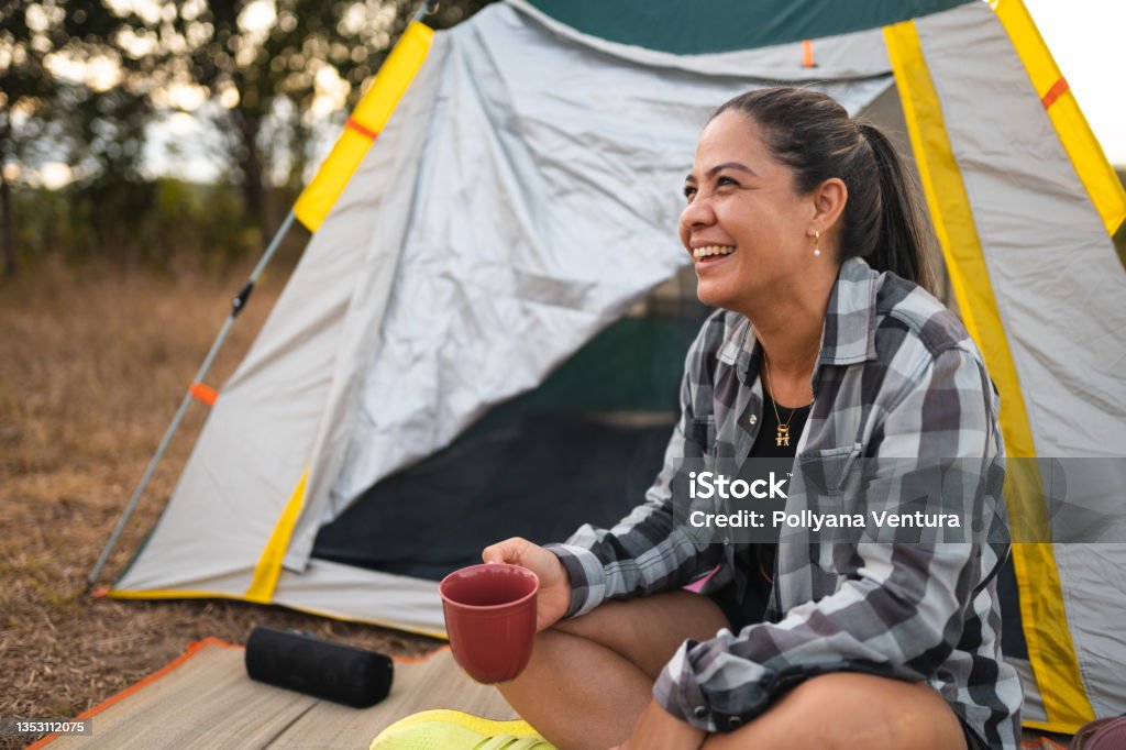 Woman drinking coffee at camp in forest Camping, Sunset, Nature, Day, Sunny Camping Stock Photo