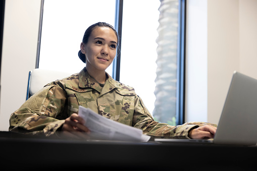 A female Air Force Military member in the office with a computer