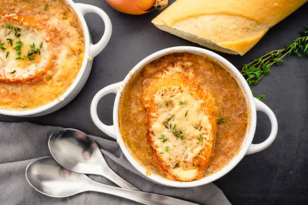 Bowls of French onion soup garnished with fresh thyme