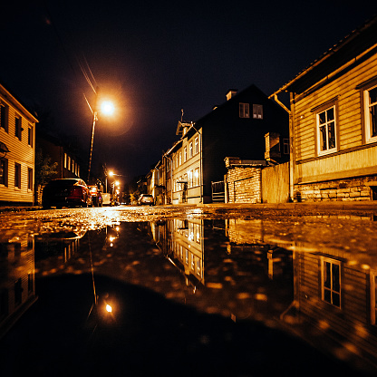 Street reflected in puddle.\nUus Maailm district, Tallinn, Estonia