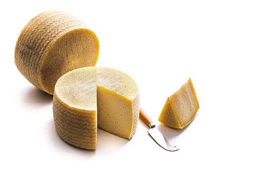 Queso Manchego cheese two cheese wheel isolated on white background, studio shot cut out