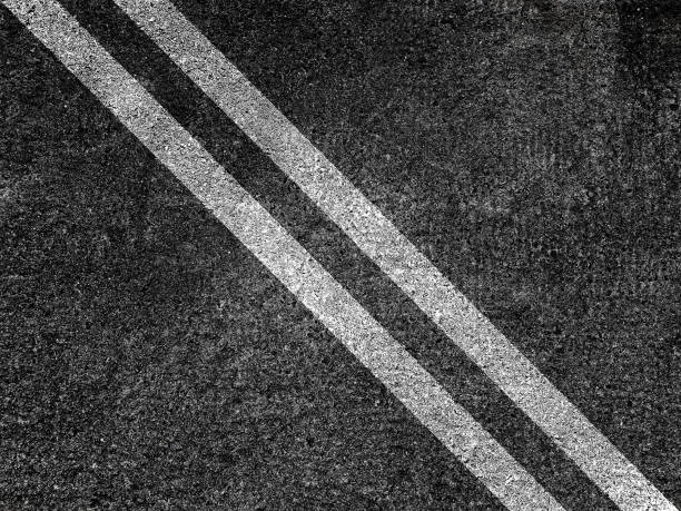 istock Double white lines on asphalt road background. 1353118734