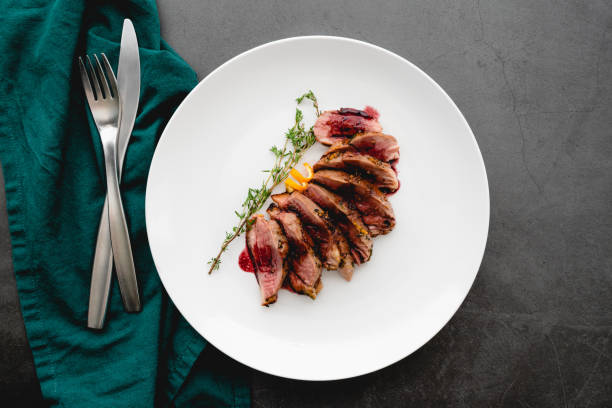 Pan-Seared Wild Duck Breast with Port Wine Reduction Sliced duck breast topped with a port wine sauce duck meat stock pictures, royalty-free photos & images