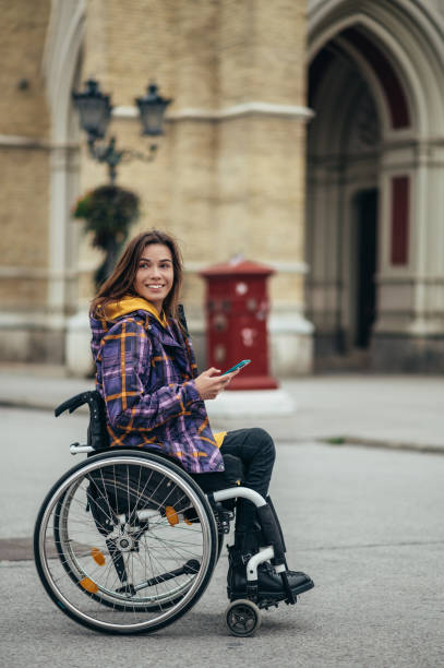 istock Woman with disability using a smartphone while out in the city 1353124127