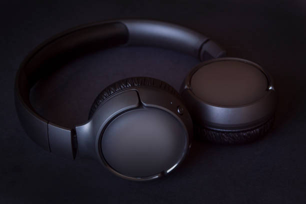 istock modern black wireless headphones with bluetooth system, on black textured background 1353130032