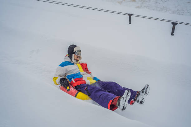 istock man snow tubing from hill. winter activity concept 1353136208