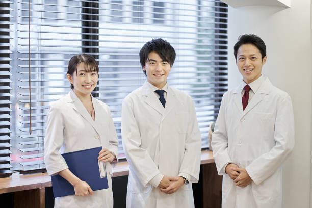 personale medico asiatico in piedi con un sorriso - research smiling scientist women foto e immagini stock