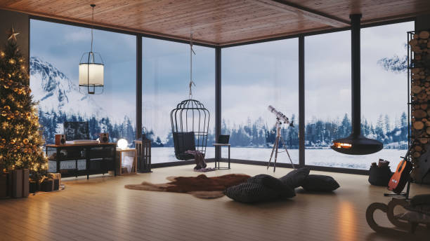 Christmas Celebration At Cozy Cottage Interior of a modern cozy lake house with fireplace and Christmas decorations in the winter. hotel window view stock pictures, royalty-free photos & images