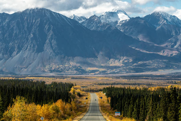 istock Scenic highway leading to huge mountains in fall. 1353152870