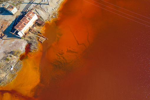 Aerial view of the toxic waste settling tank. Red water due to emissions into the reservoir of toxic substances from the beneficiation plant. The impact of industry on the environment.