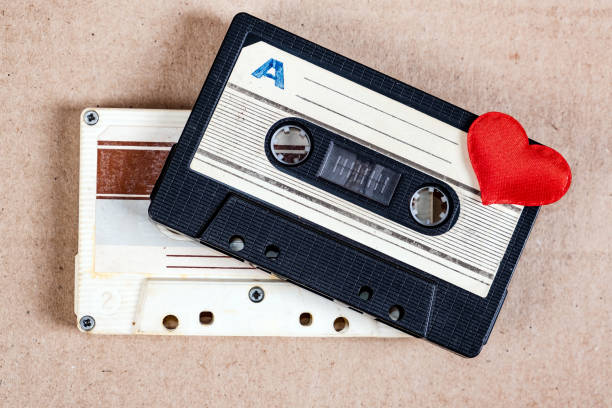 Old Audio Cassettes Two Old Audio Cassettes with a Red Heart on the Paper Background closeup mix tape heart stock pictures, royalty-free photos & images