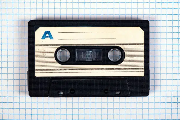 Old Audio Cassette on the Square Paper Background closeup