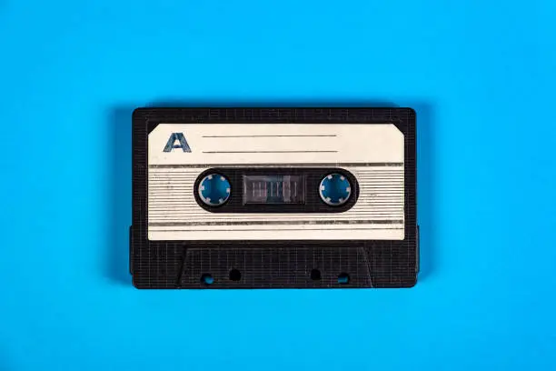 Old Audio Cassettes on the Blue Paper Background closeup