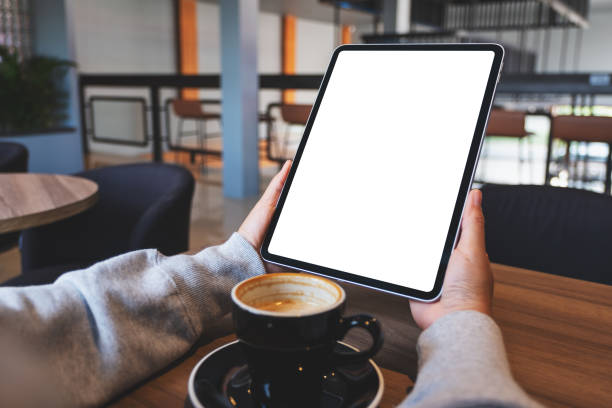 istock a woman holding digital tablet with blank white desktop screen in cafe 1353158284