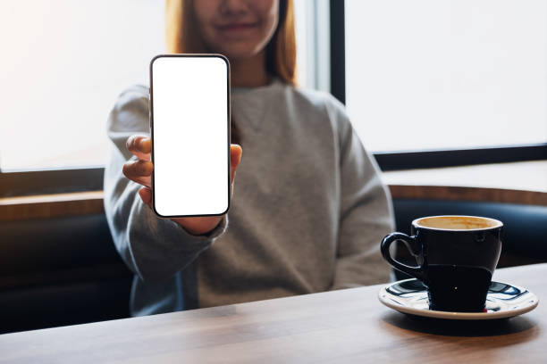istock a beautiful woman showing a mobile phone with blank white screen 1353158297