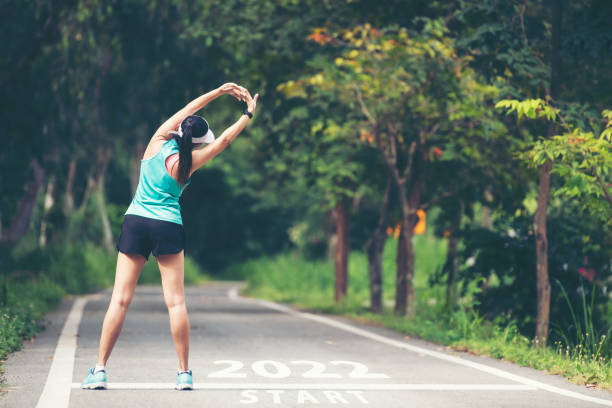 the start into the new year 2022. start up of runner woman running on nature race track go to goal of success.  people running as part of number 2022. - condition optimal text healthy lifestyle imagens e fotografias de stock