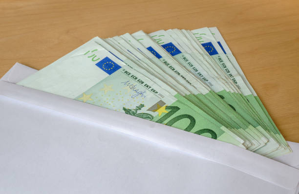 istock Various fanned out Euro banknotes in a white envelope. 1353162347