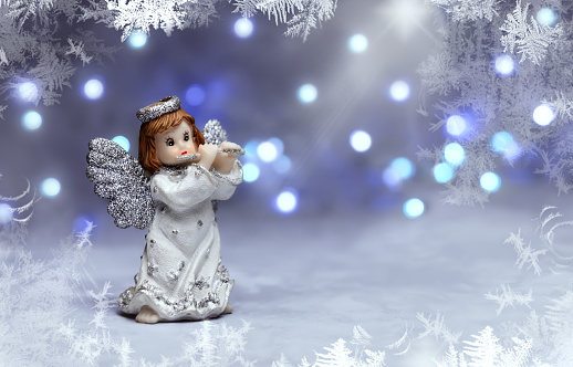 Angel on a gray-blue background with a bokeh and a frame made of frost.
