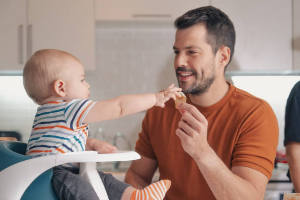 istock handsome young father feeding his son 1353163325